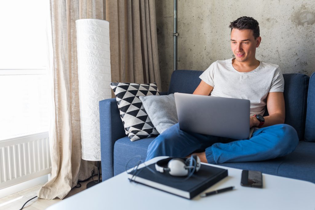 A man sitting on a couch with a laptop